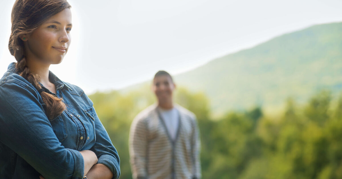 A man and woman standing in evening light outdoors