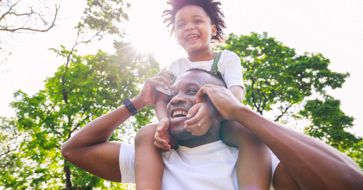 African american father giving son ride on back