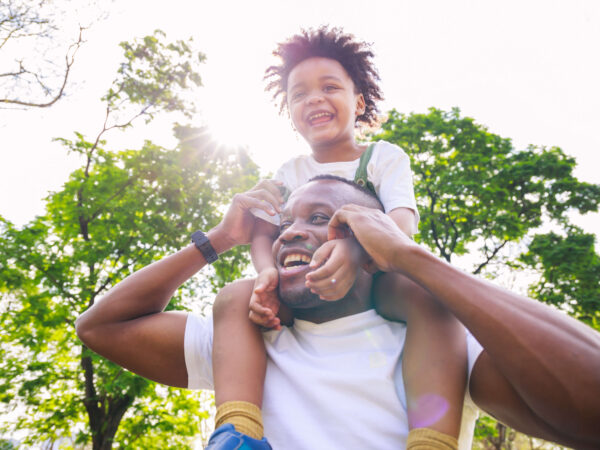 African american father giving son ride on back