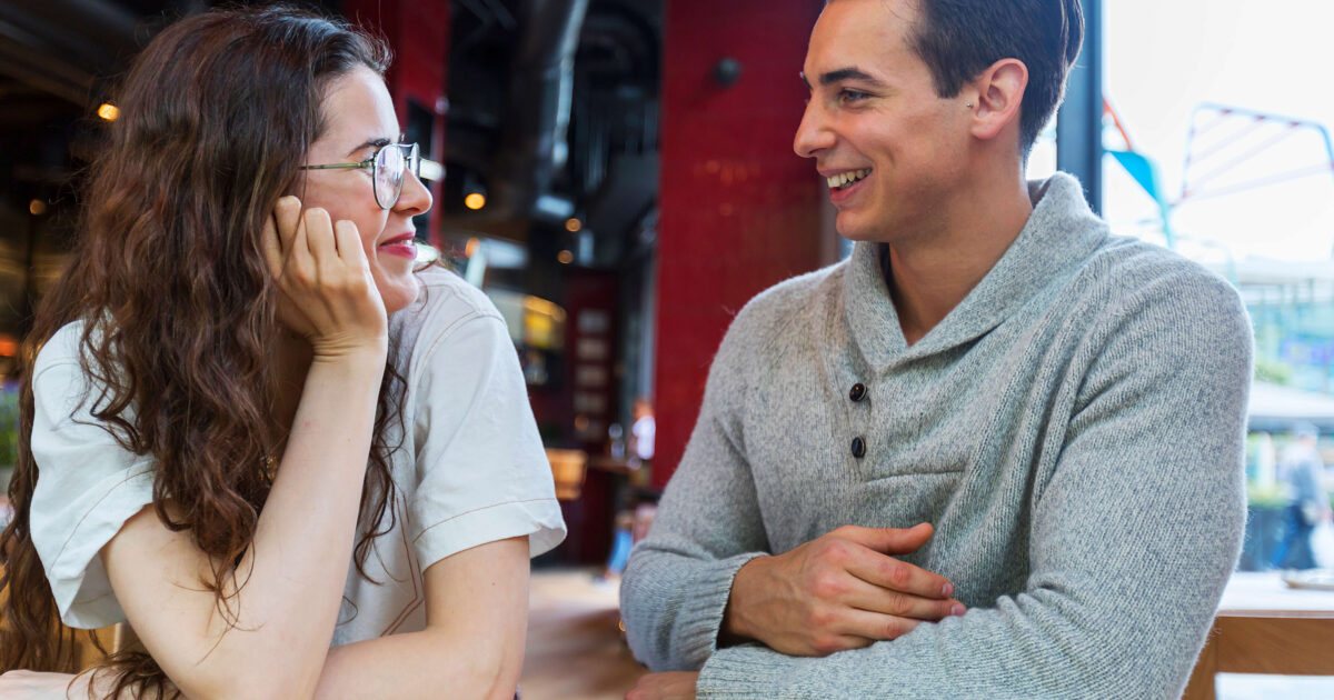 Couple sitting at table and talking in coffee shop