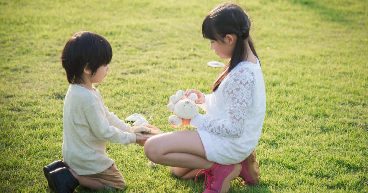 Two kids playing in the grass