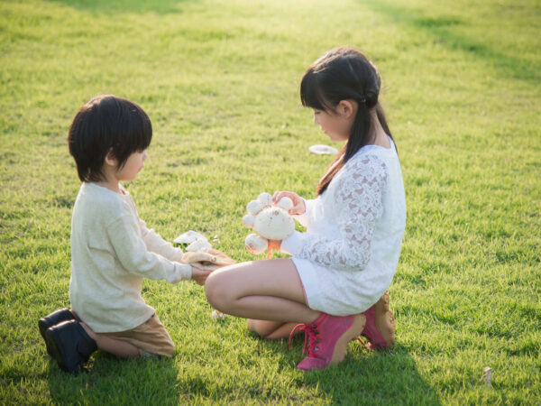 Two kids playing in the grass