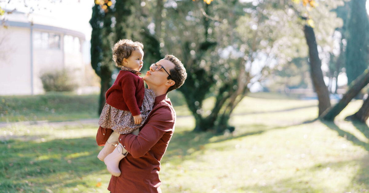 dad holds a little girl in his arms