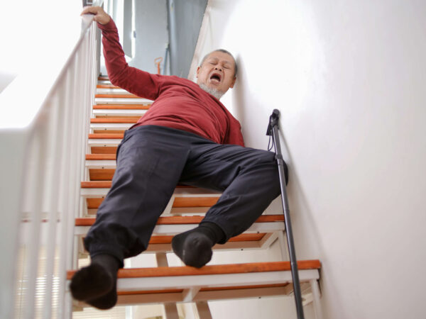 Elderly asian man lying on staircase after slip and fall