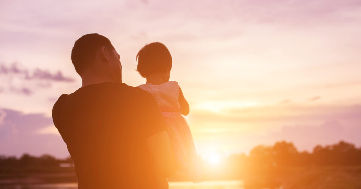 Father took the baby learn to walk at sunset
