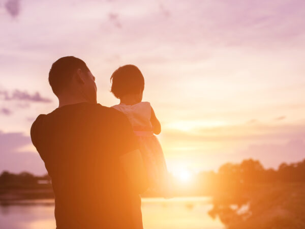 Father took the baby learn to walk at sunset