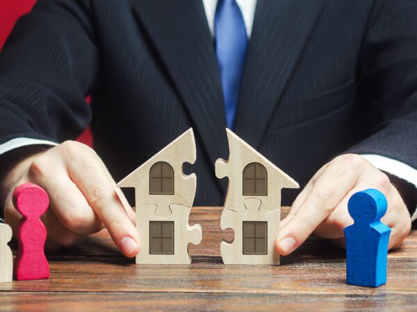 Lawyer splitting a paper house indicating property division after a divorce