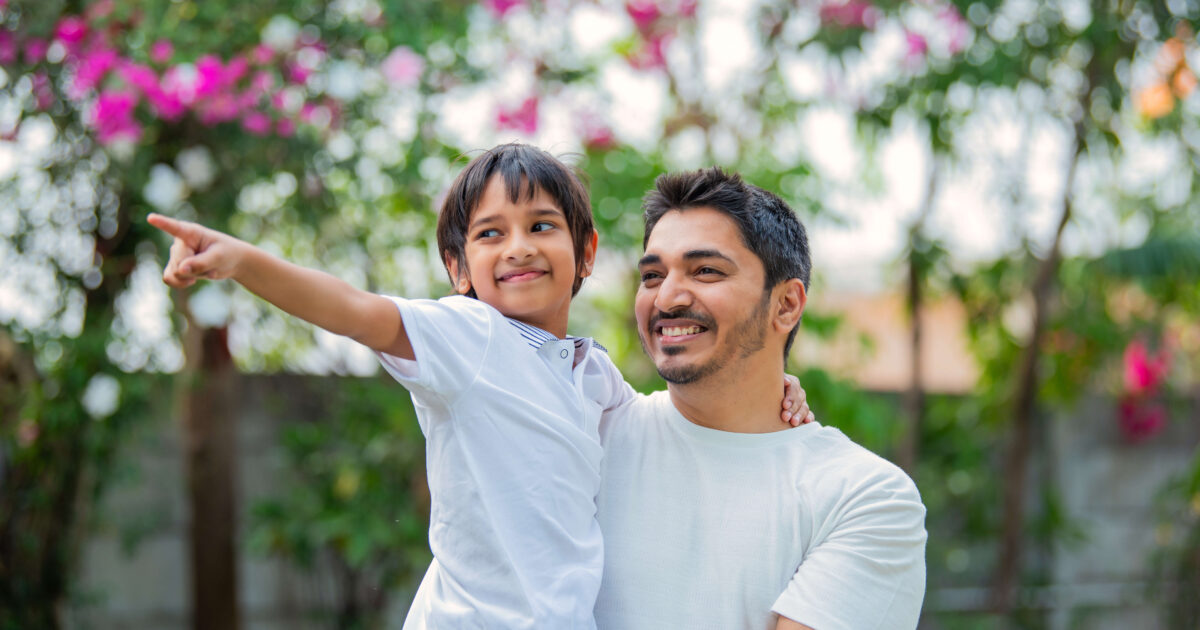 Young father carrying his son in the park