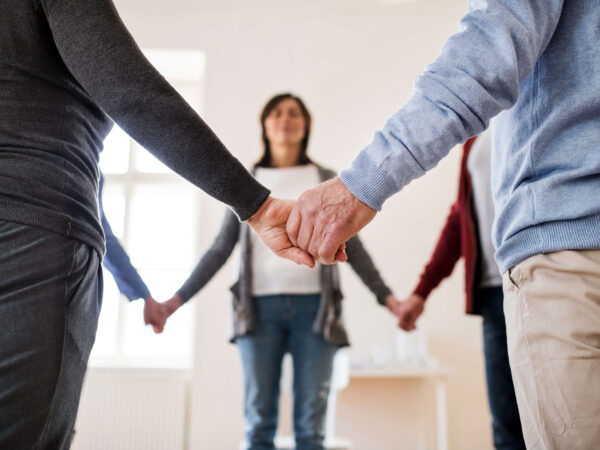 People holding their hands together as in a group class
