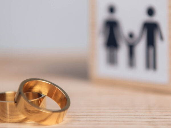 Image of weeding rings in a table with a representation of a family in the back