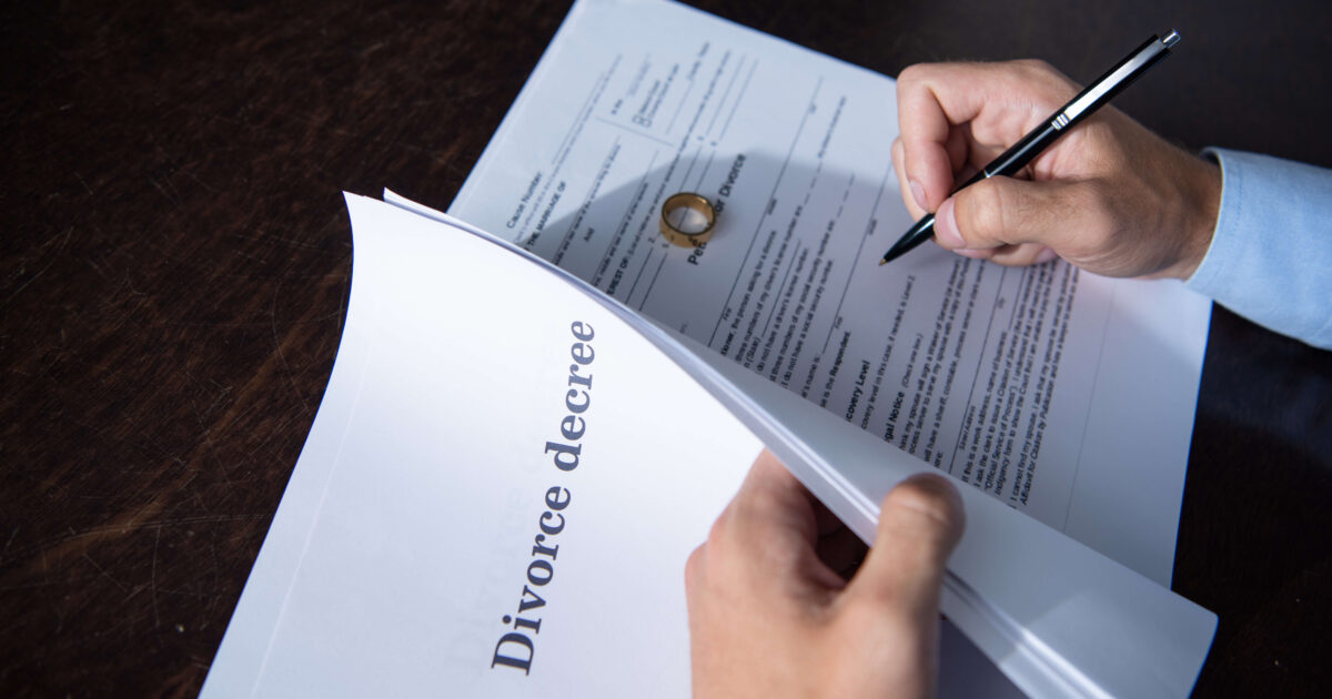Partial view of man sitting at table and signing