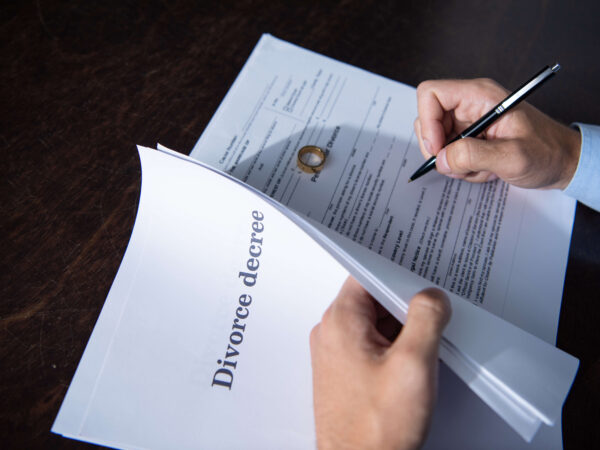 Partial view of man sitting at table and signing