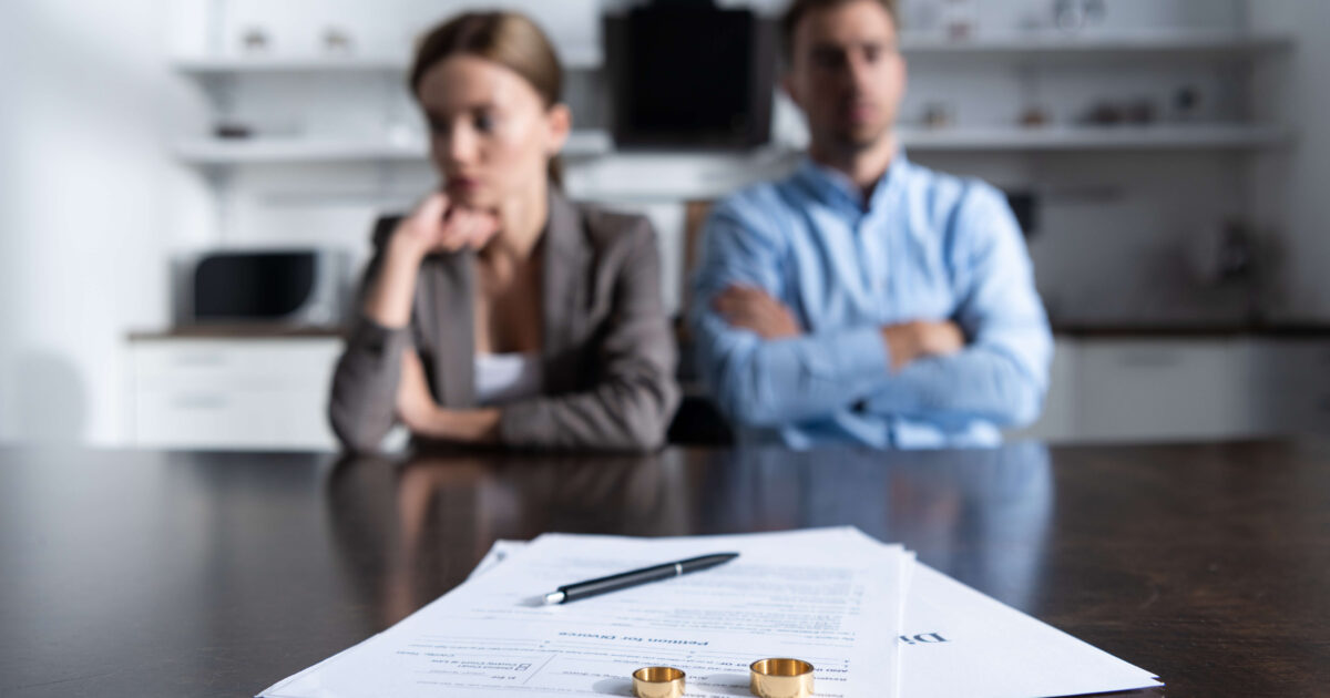 couple sitting at table with divorce papers