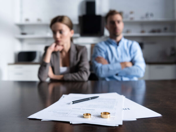 couple sitting at table with divorce papers