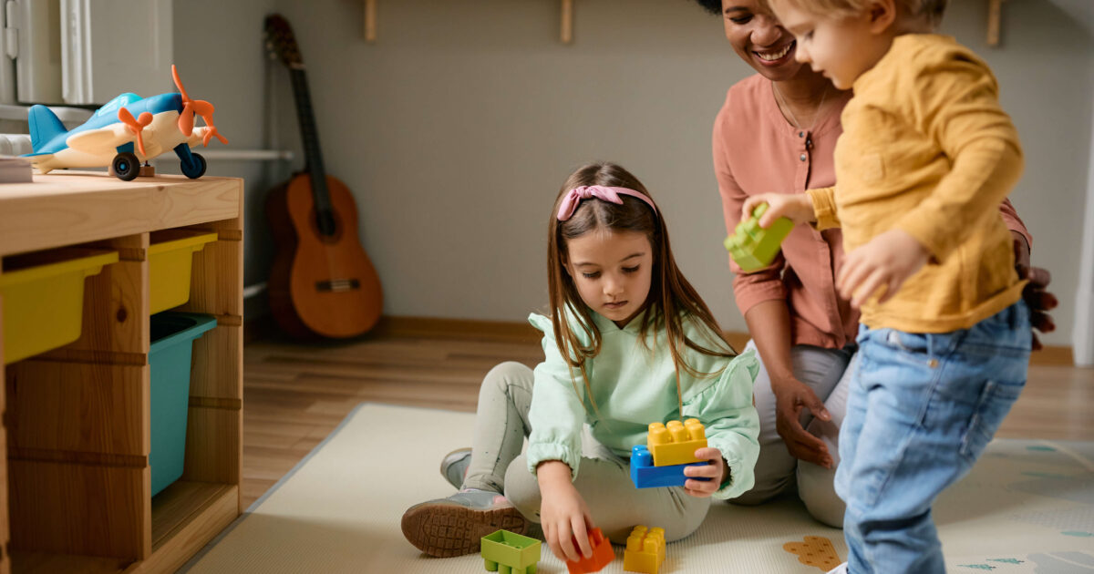 Small kids and their-african american nanny playing