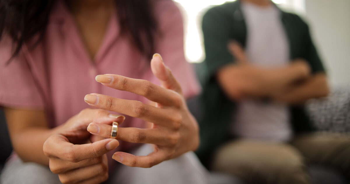 Woman's hand removes wedding ring