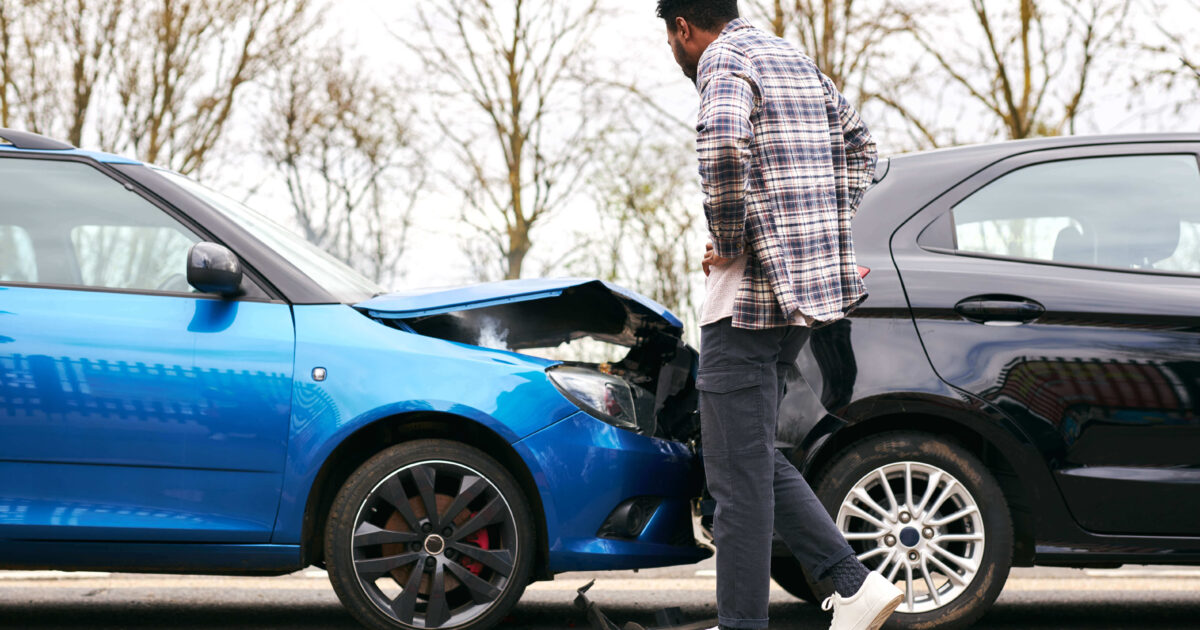 A man evaluating the damage on his car after a fresh car accident