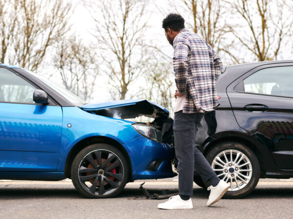 A man evaluating the damage on his car after a fresh car accident